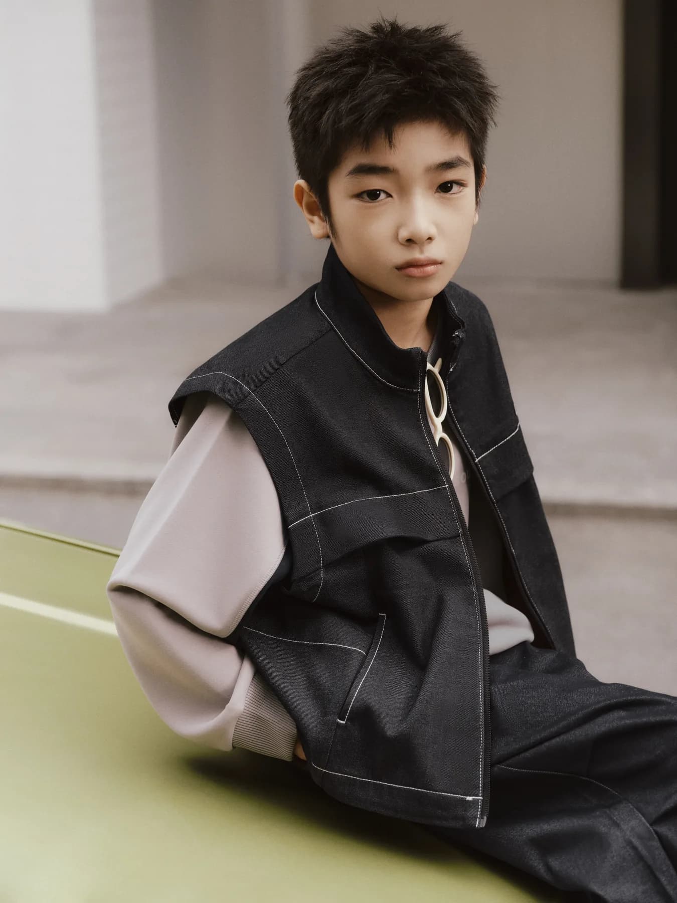 孩子穿着亚瑟士儿童服饰坐在城市空间
